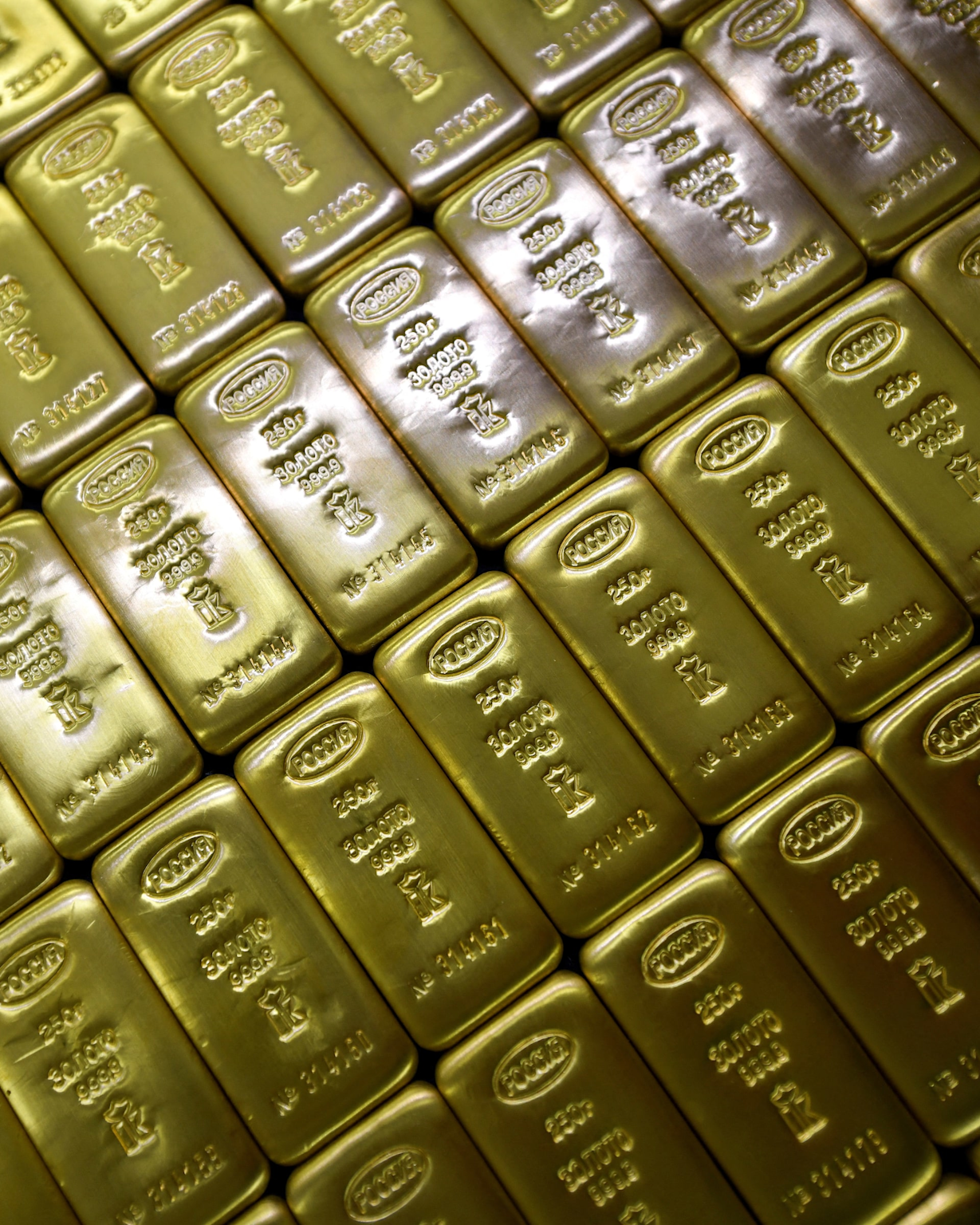 Russian gold bullion bars stacked, showing inscriptions in Russian, illustrating physical gold holdings